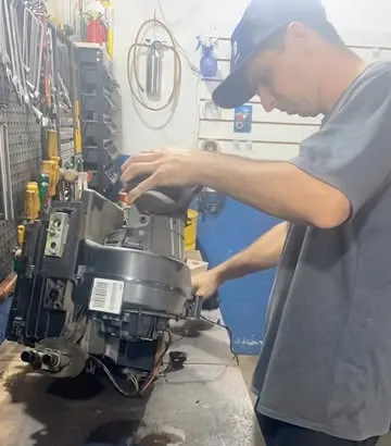 Técnico da AWB desmontando a caixa do evaporador na bancada